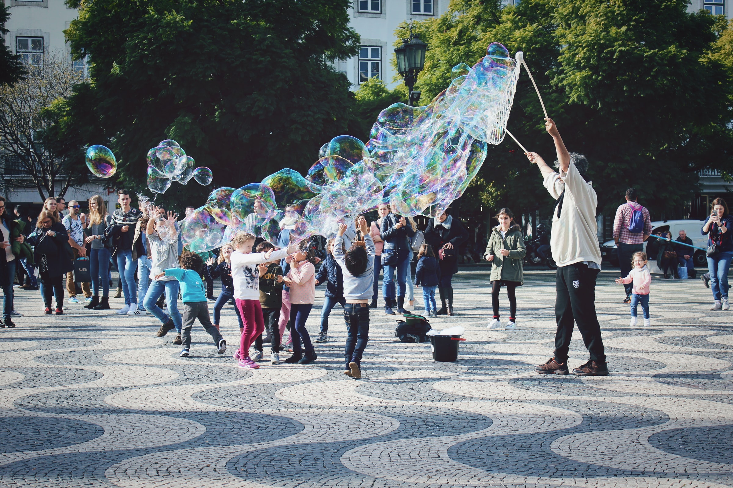 Kids playing with large bubbles.