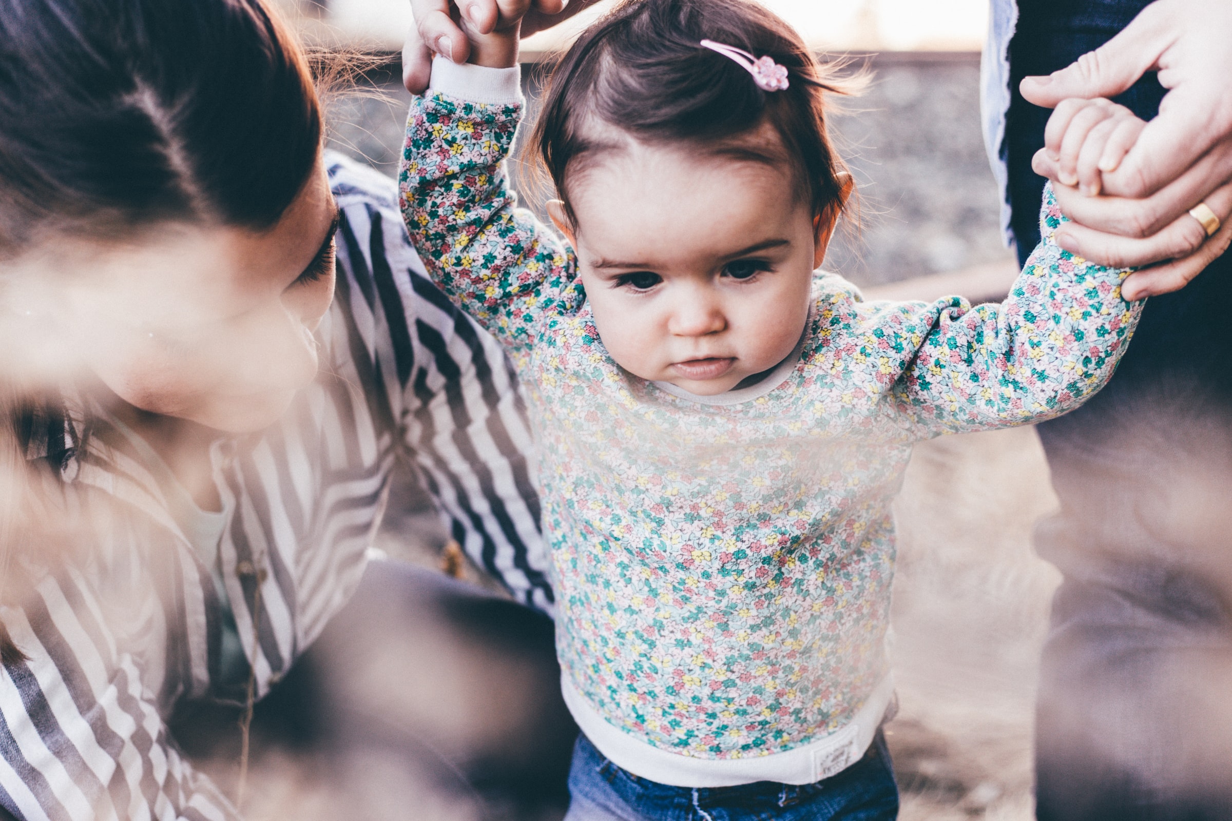 A toddler getting some help walking.