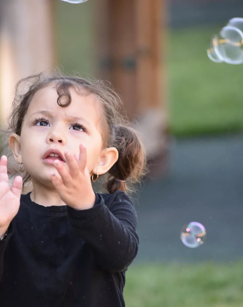 girl transfixed with bubbles
